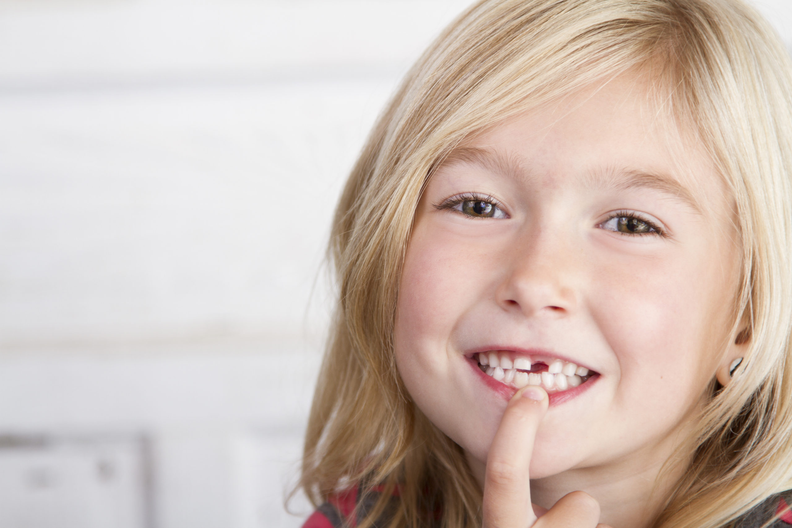 Child,Missing,Front,Tooth,Pointing,At,It,With,Her,Finger
